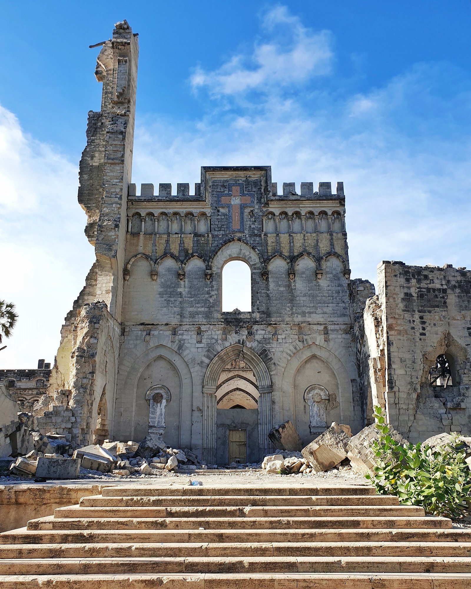 The ruined Norman-Gothic facade of Mogadishu Cathedral, its truncated tower and pointed portals standing without a roof