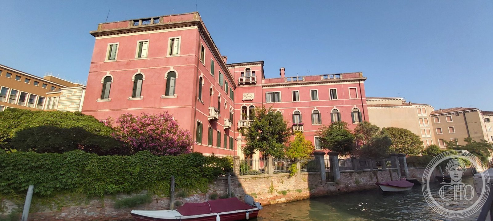 Canal-side garden with oleanders in front of the red palazzo ai Tolentini, Venice