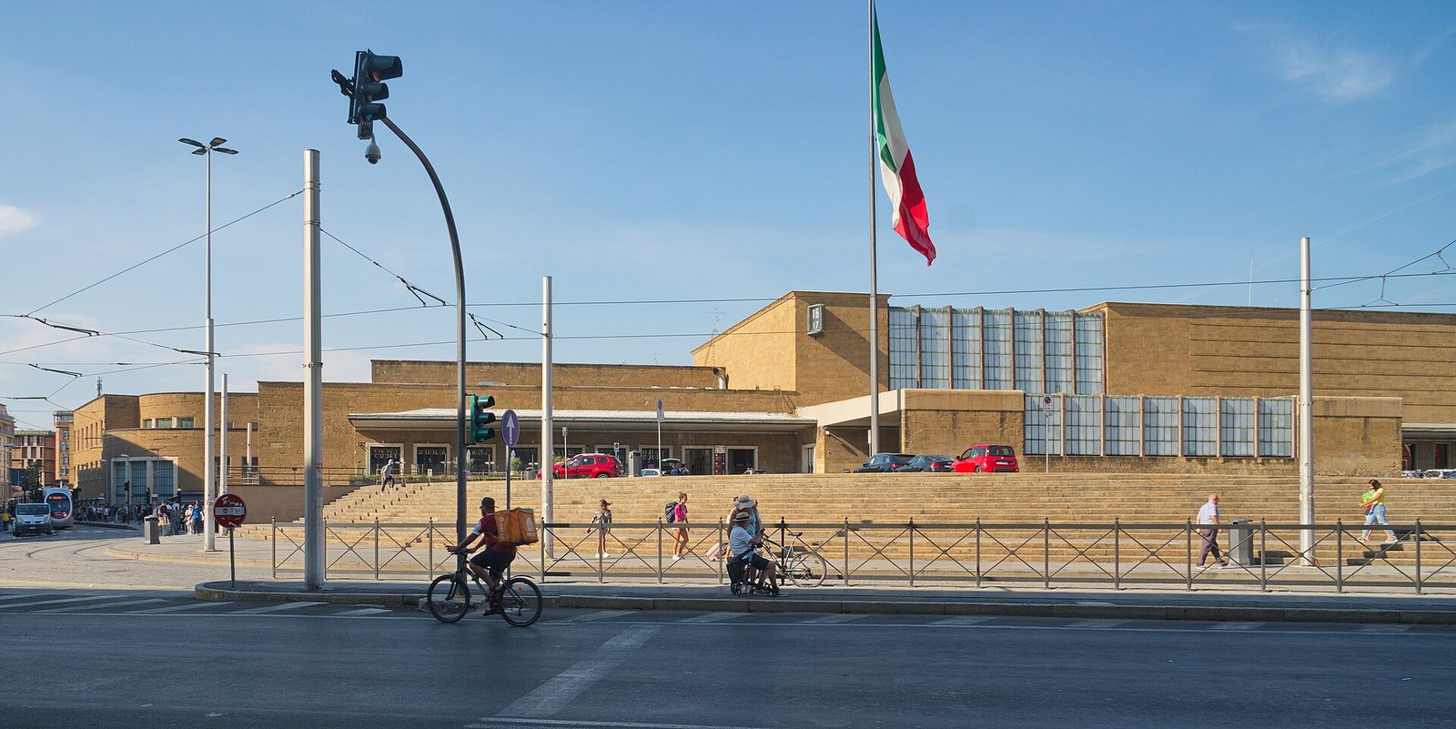 The low pietraforte facade of Florence Santa Maria Novella station, with its long glazed head-gallery and broad entrance steps