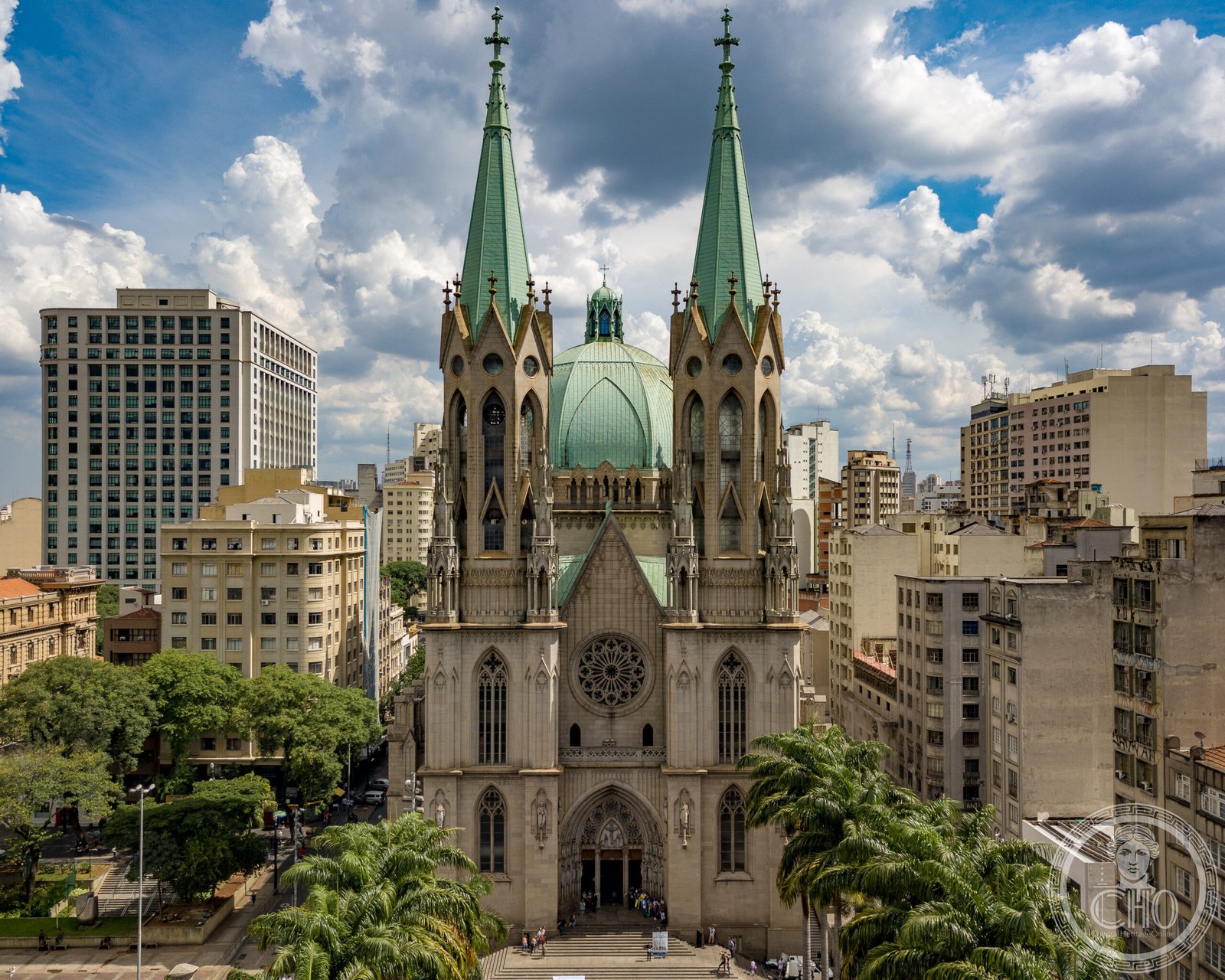 Sé Cathedral of São Paulo, Brazil, a neo-Gothic facade with twin green-spired towers and a Renaissance-style dome, surrounded by downtown skyscrapers