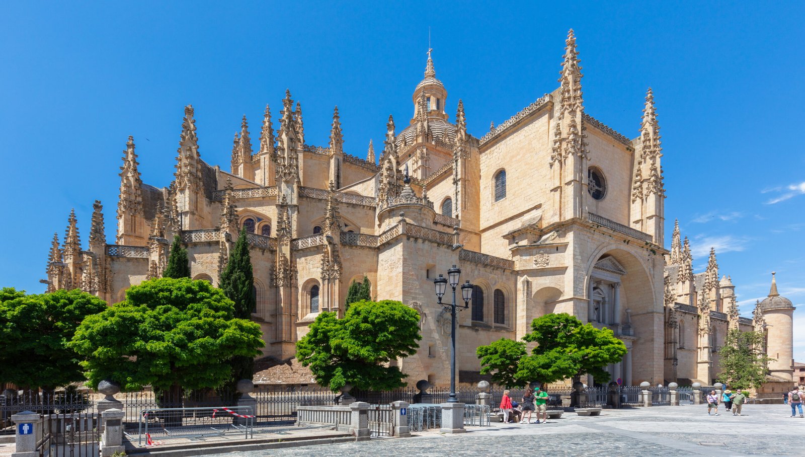 Segovia Cathedral seen from Plaza Mayor, its late-Gothic mass of honey-coloured stone bristling with pinnacles under a crossing dome