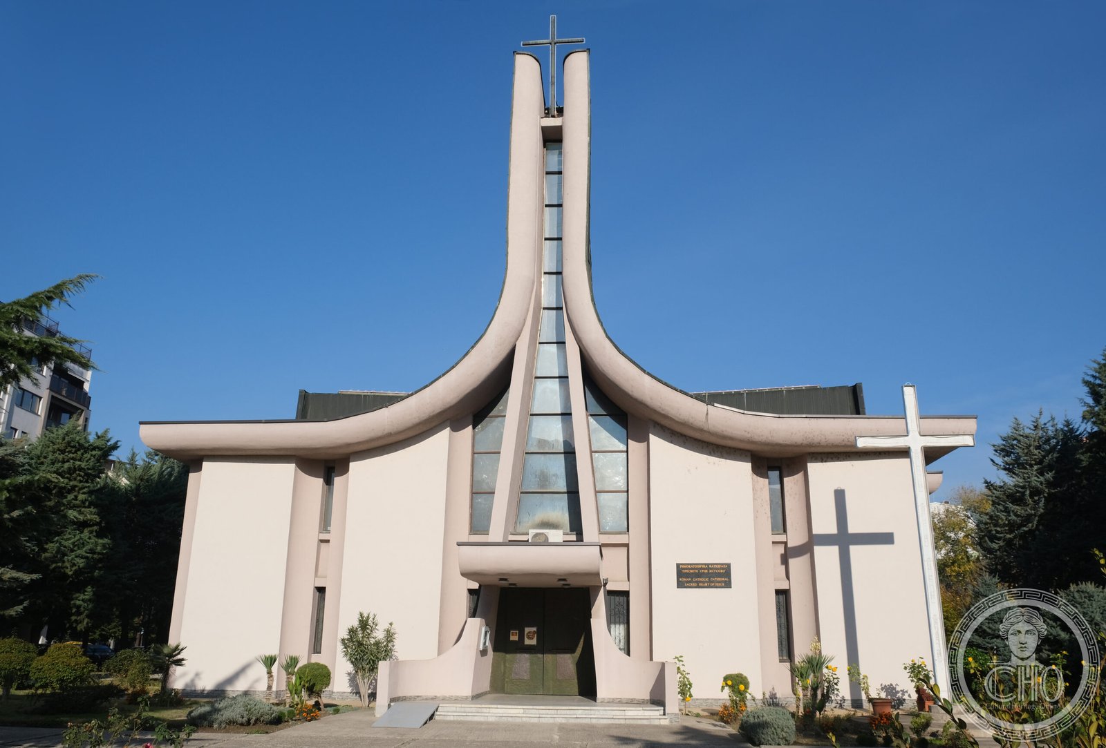 Cathedral of the Sacred Heart of Jesus in Skopje, North Macedonia, a modernist building with curved concrete wing-shaped pylons meeting at a tall cross