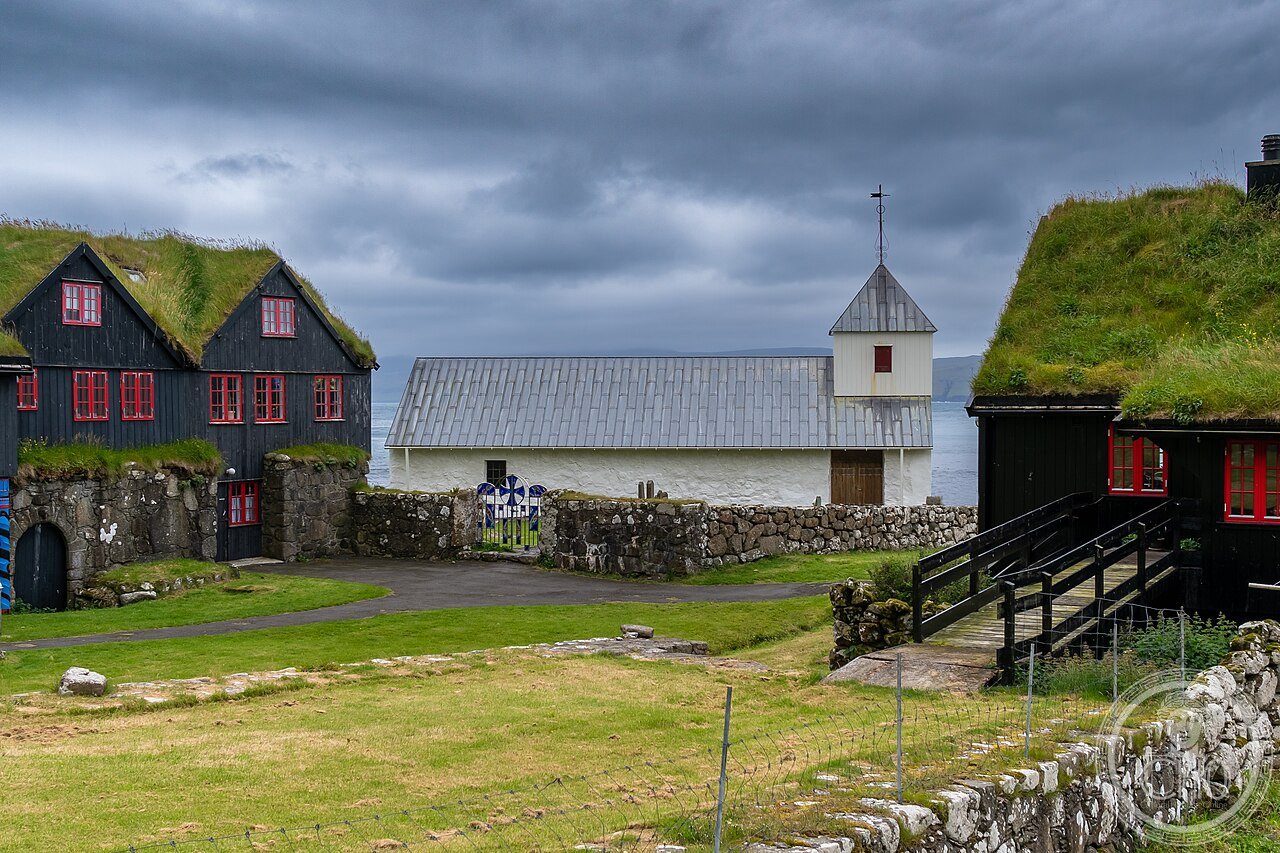 St Olav's Church at Kirkjubøur, Faroe Islands, a small stone Romanesque church traditionally dated to around 1111, the oldest church still in regular use in the islands, beside the historic Kirkjubøargarður farmhouse