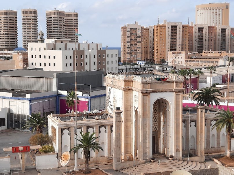 Monumental arched gate of the Tripoli International Fair with pavilions behind