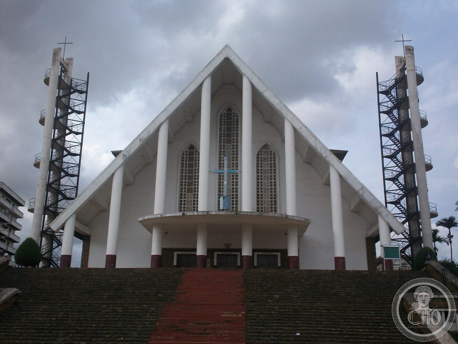Notre-Dame-des-Victoires Cathedral in Yaoundé, Cameroon, a modernist white cathedral with twin bell towers, begun in 1952 and still technically unfinished decades later