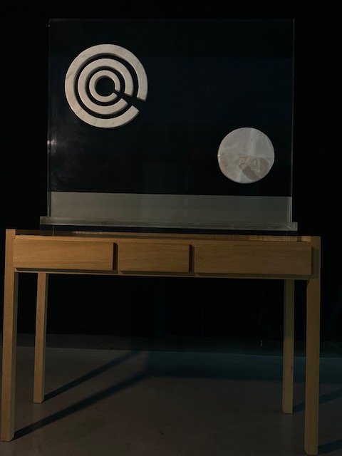 Sculpture in white marble and onyx set against a Perspex panel, with a spiral and a disc