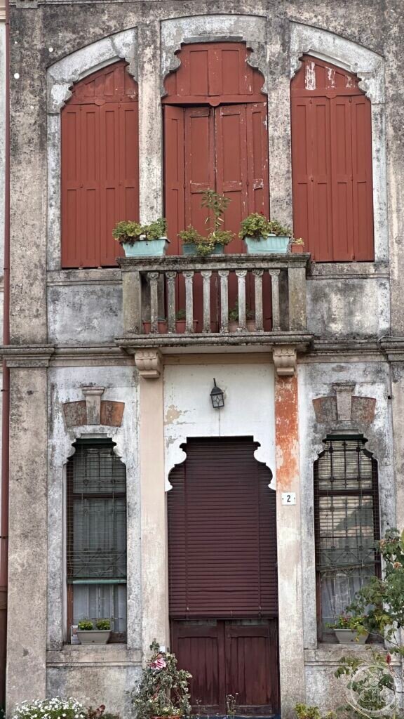 Detail of the first-floor triple window and stone balustraded balcony