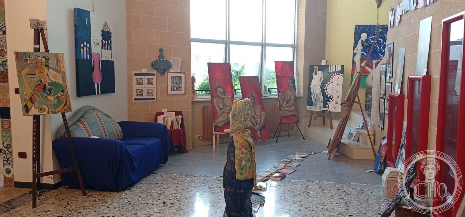The exhibition hall with paintings on easels and on the walls at the Casa degli Artisti in Gallipoli