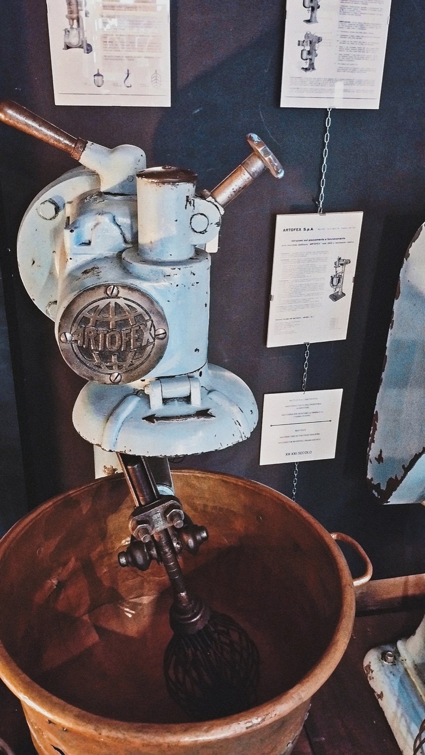 Artofex mixer head with a whisk lowered into a copper bowl