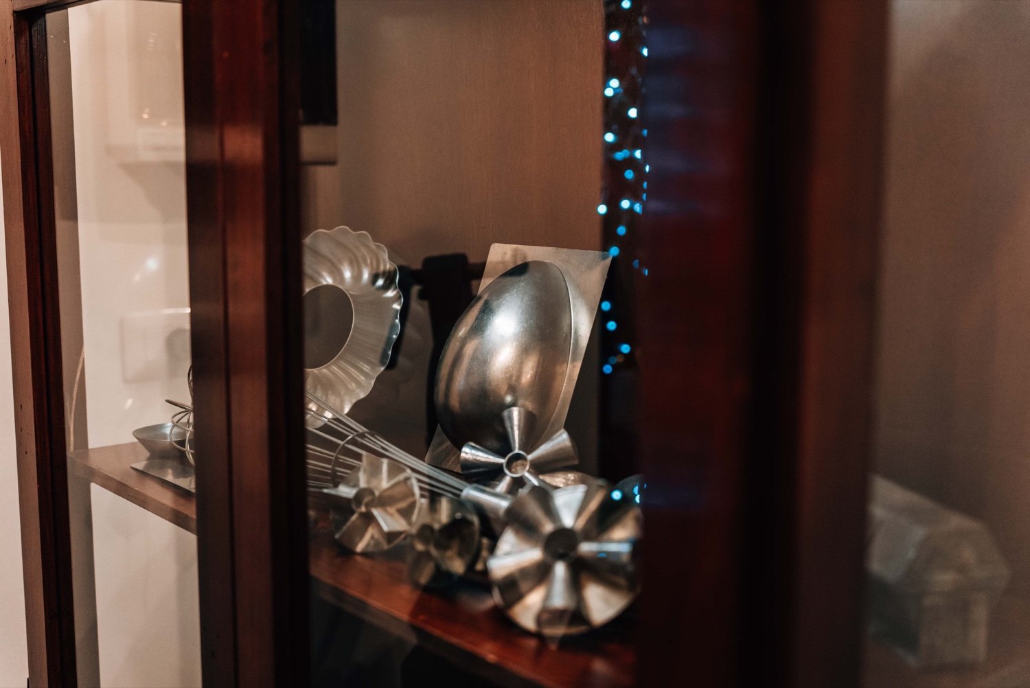 Tinplate moulds and hand tools in a glazed display case