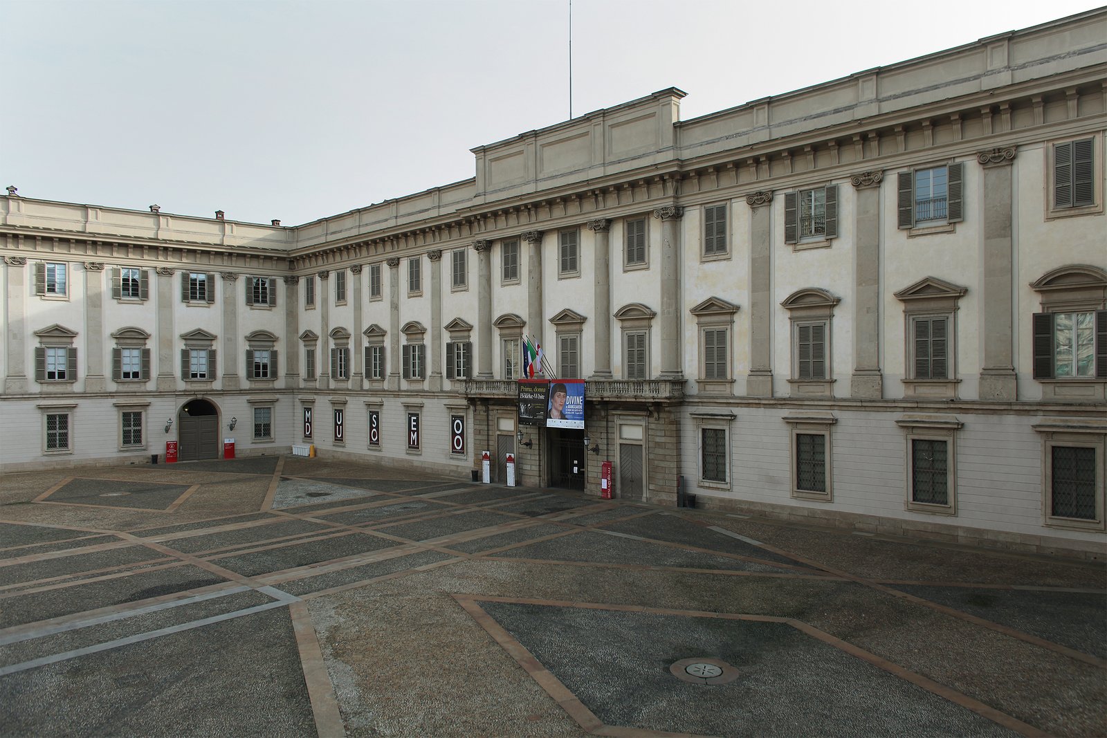 Three-quarter view of the neoclassical facade of Palazzo Reale in Milan, next to the Duomo