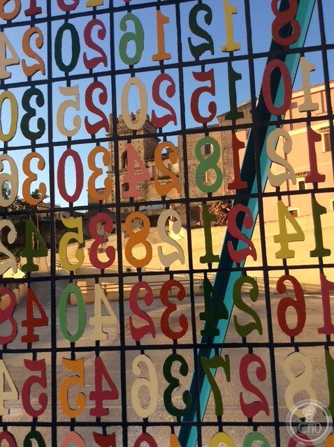 Close view of the cut-out numerals of the table, seen in mirror image from the inner side