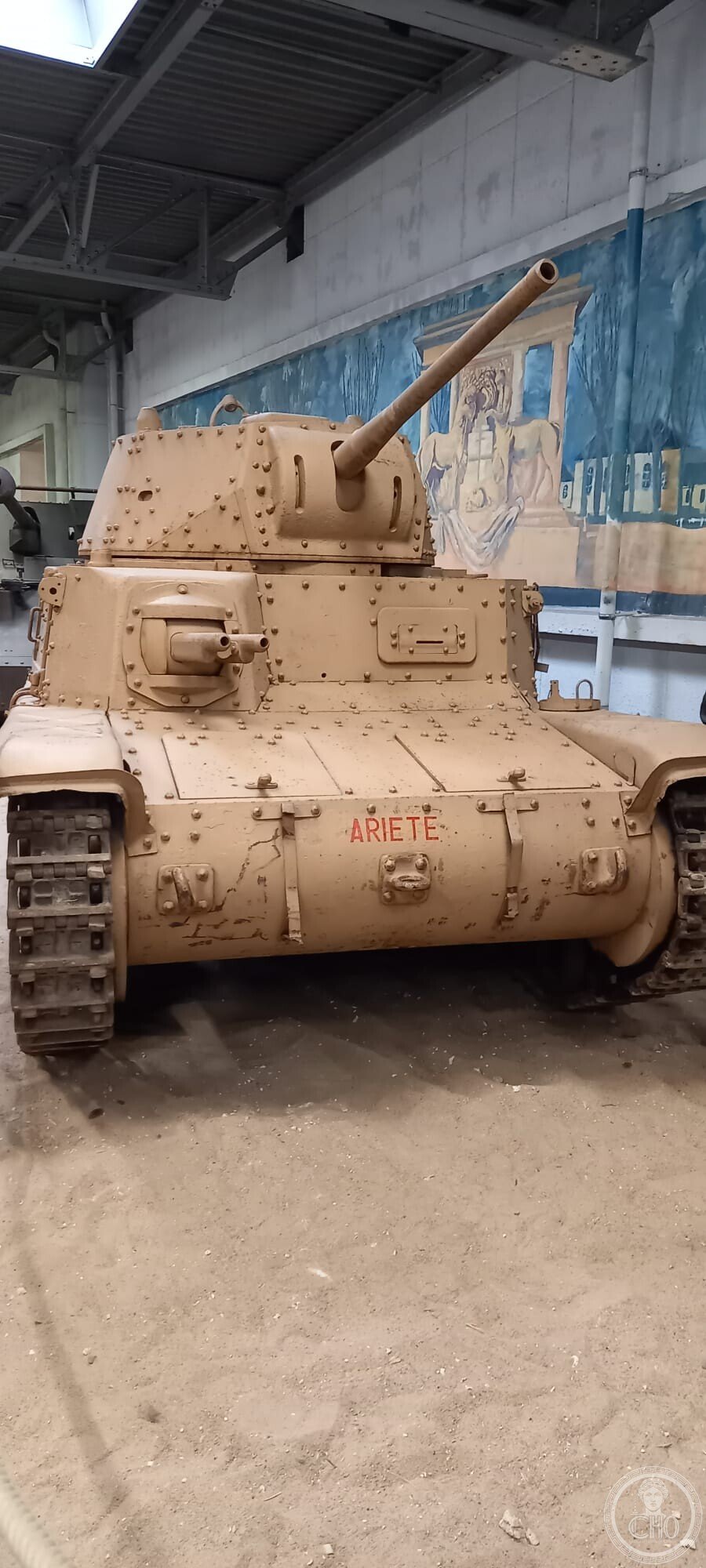 Frontal view of the sand-coloured M15/42 tank with ARIETE painted in red on the hull front and the hull machine gun beside it