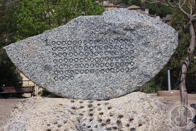 The other face of the upper slab, carved with a 1 followed by rows of drilled zeros