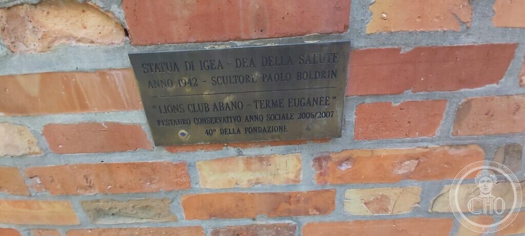 The brass plate on the brick pedestal of the Hygieia statue