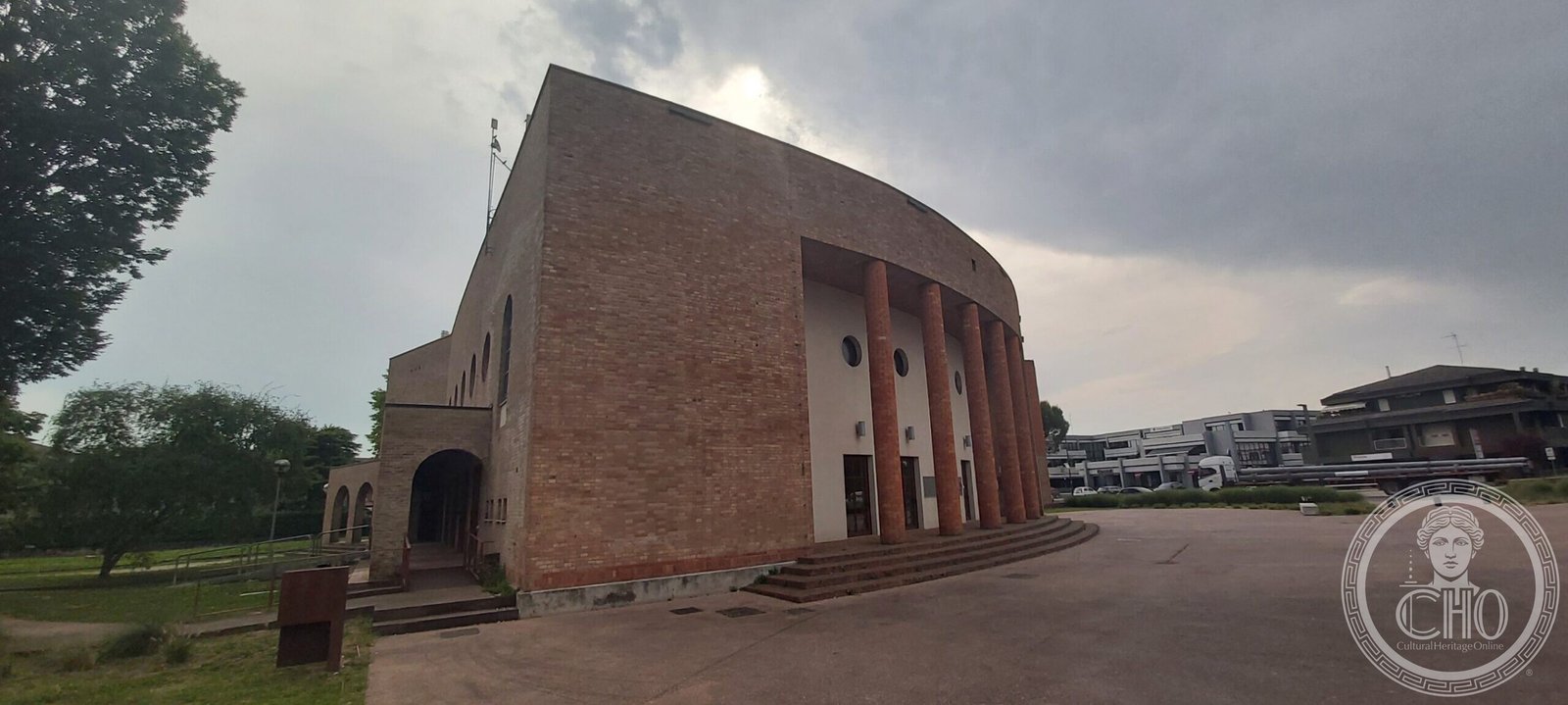 Teatro Quirino De Giorgio Vigonza — the blank brick flank and the convex front seen from the side
