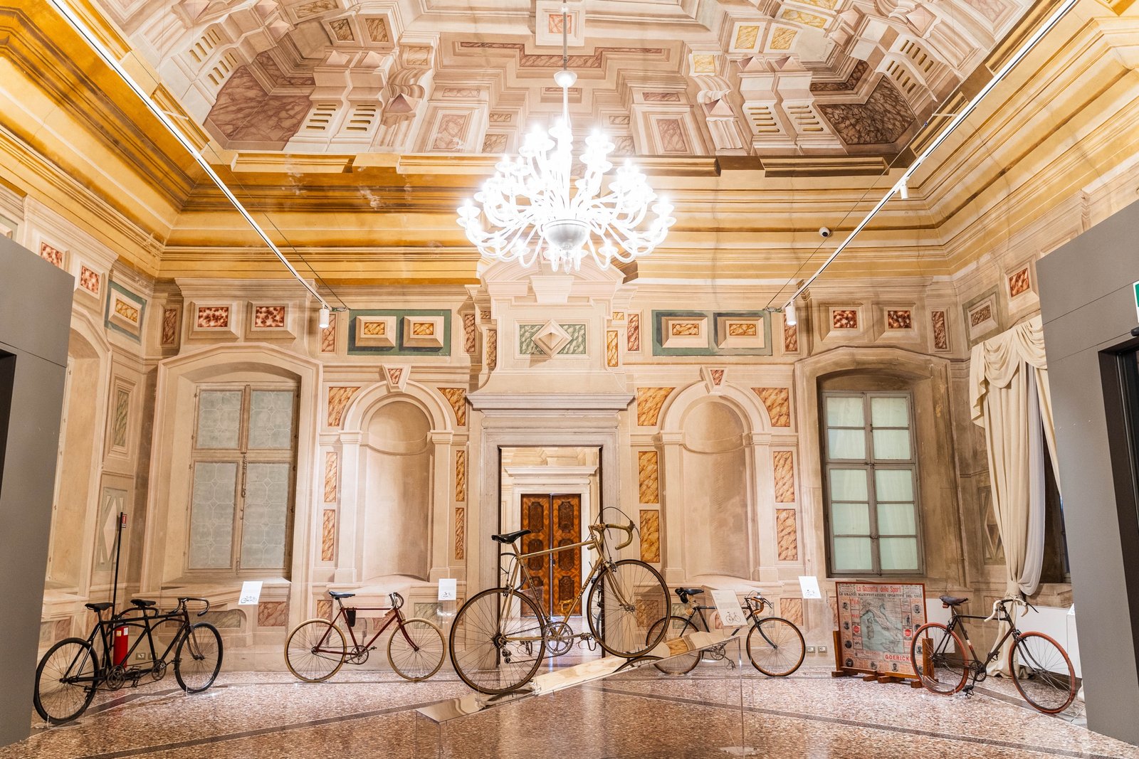 Historic bicycles on display in a frescoed hall of Villa Manin for the A Ruota Libera exhibition
