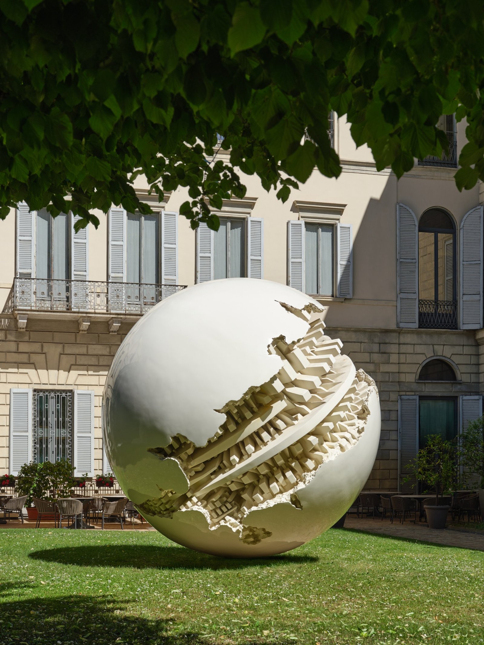 Large spherical sculpture by Arnaldo Pomodoro in the garden of Gallerie d'Italia in Milan