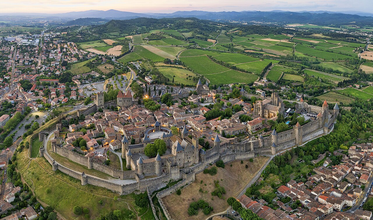 Aerial view of the fortified city of Carcassonne showing the double ring of medieval walls with 52 towers encircling the Cité on its hill above the Aude plain
