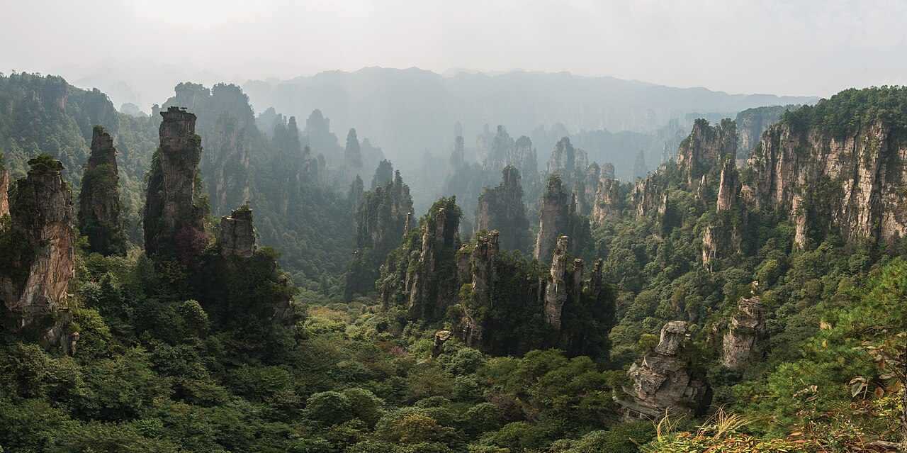 Aerial panorama of quartzite-sandstone pillars emerging from forest at Tianzishan in the Wulingyuan Scenic Area, Zhangjiajie, Hunan Province, China