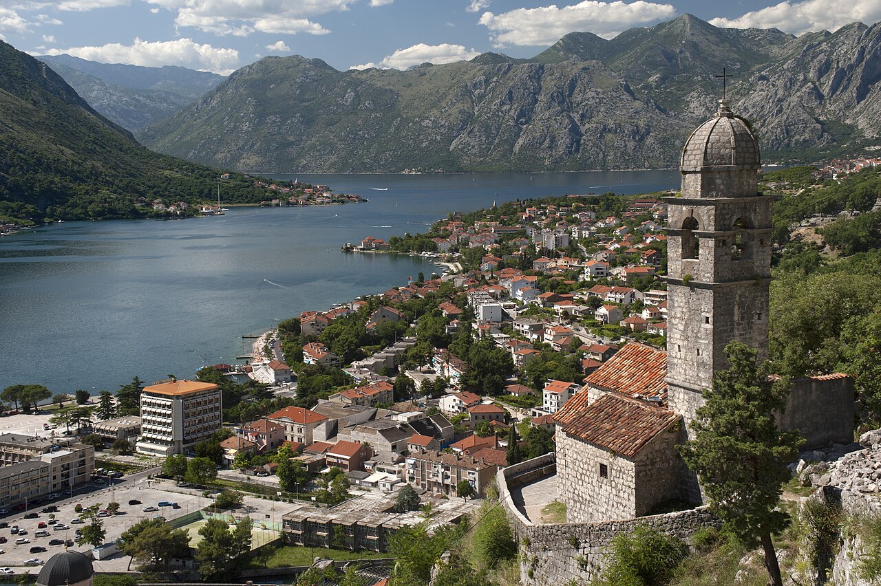 The Church of Our Lady of Health on its rocky promontory overlooking the Bay of Kotor, with the fortified old city walls climbing the mountain behind