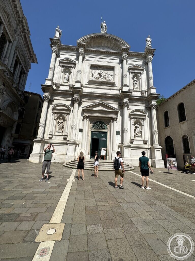 The eighteenth-century front of the church of San Rocco in Venice seen across the empty campo under a blue sky