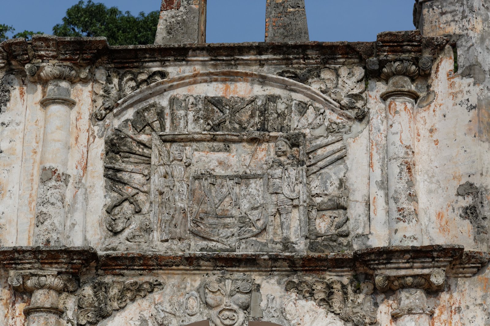 Stone archway of A Famosa Portuguese fortress ruins against a blue sky, Melaka