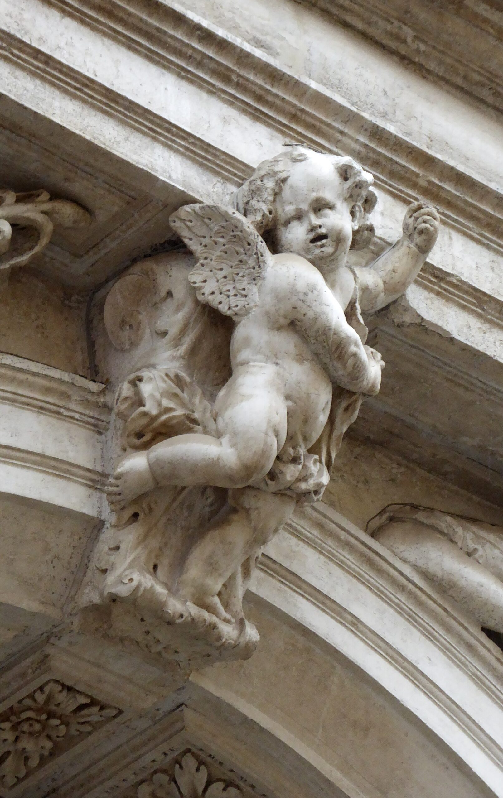 A winged putto carved on the facade