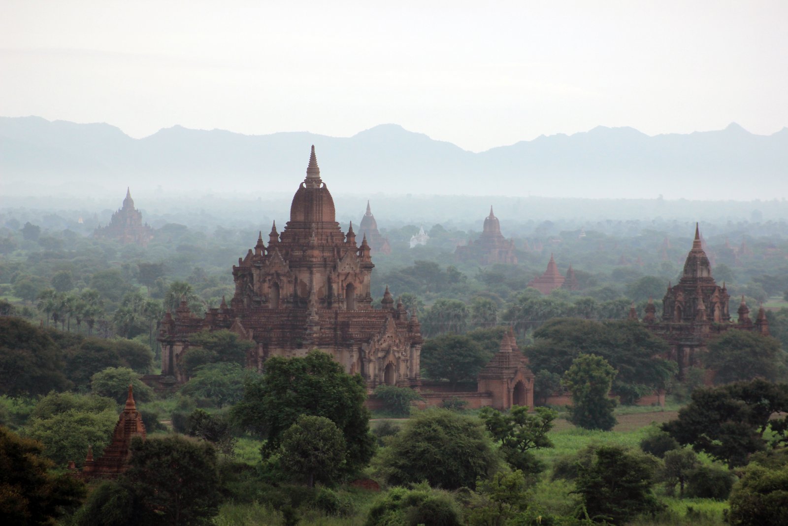 Red-brick Buddhist temples rising from the flat Bagan plain at dusk, Myanmar