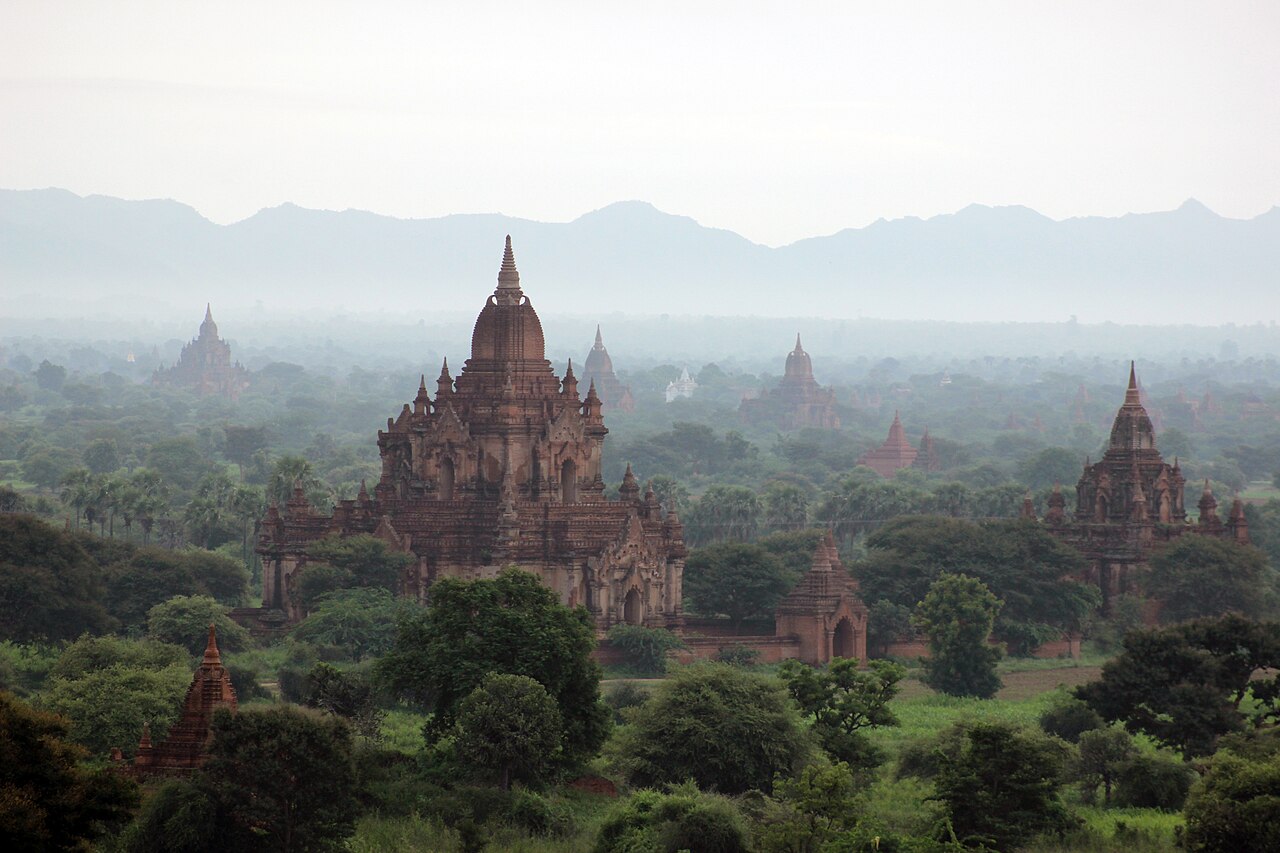 Buddhist temples rising from the flat plain of Bagan, Myanmar at dusk
