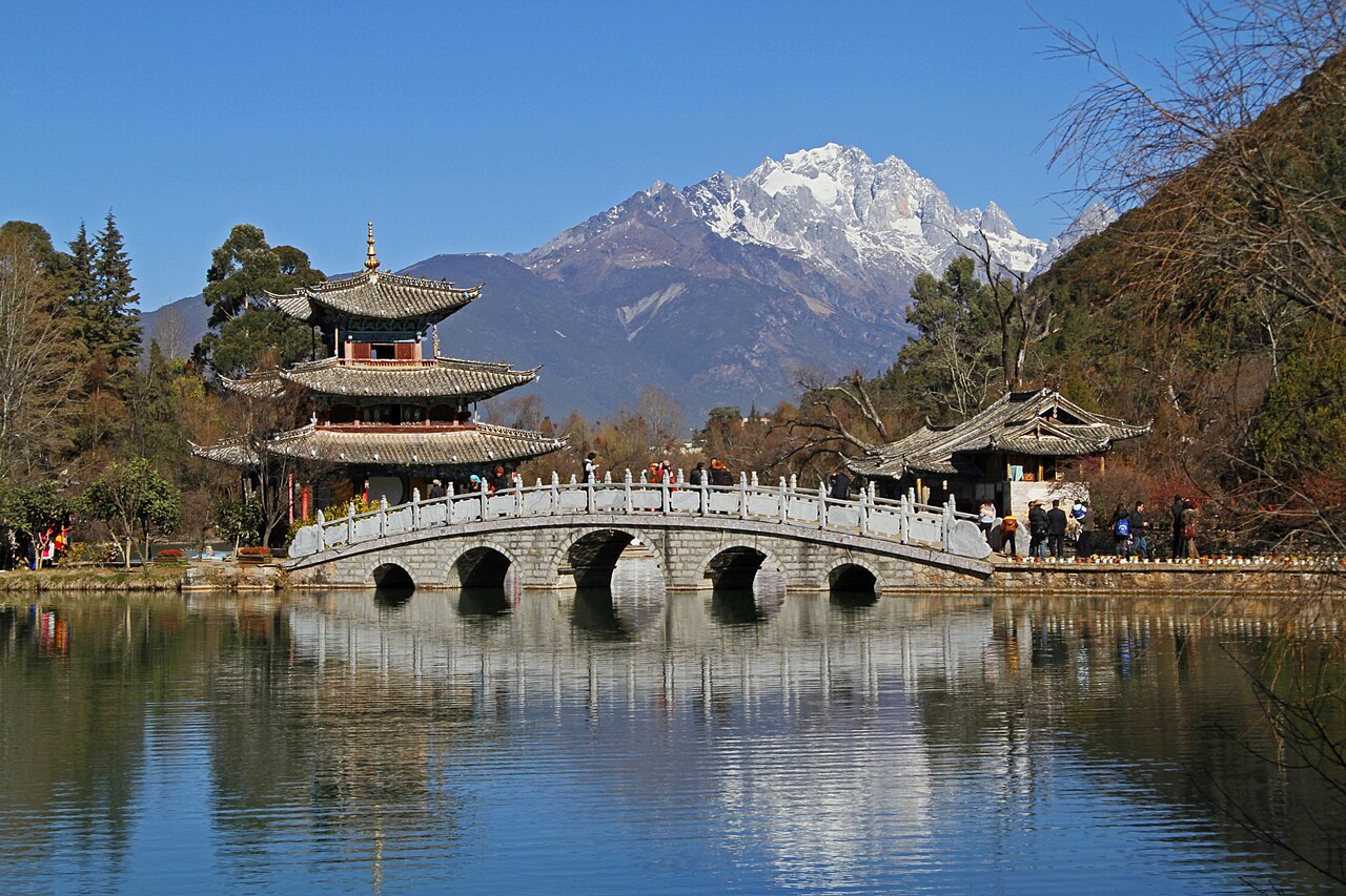 Black Dragon Pool at Lijiang with Jade Dragon Snow Mountain reflected in the water and traditional Naxi wooden pavilion in the foreground, Yunnan Province, China