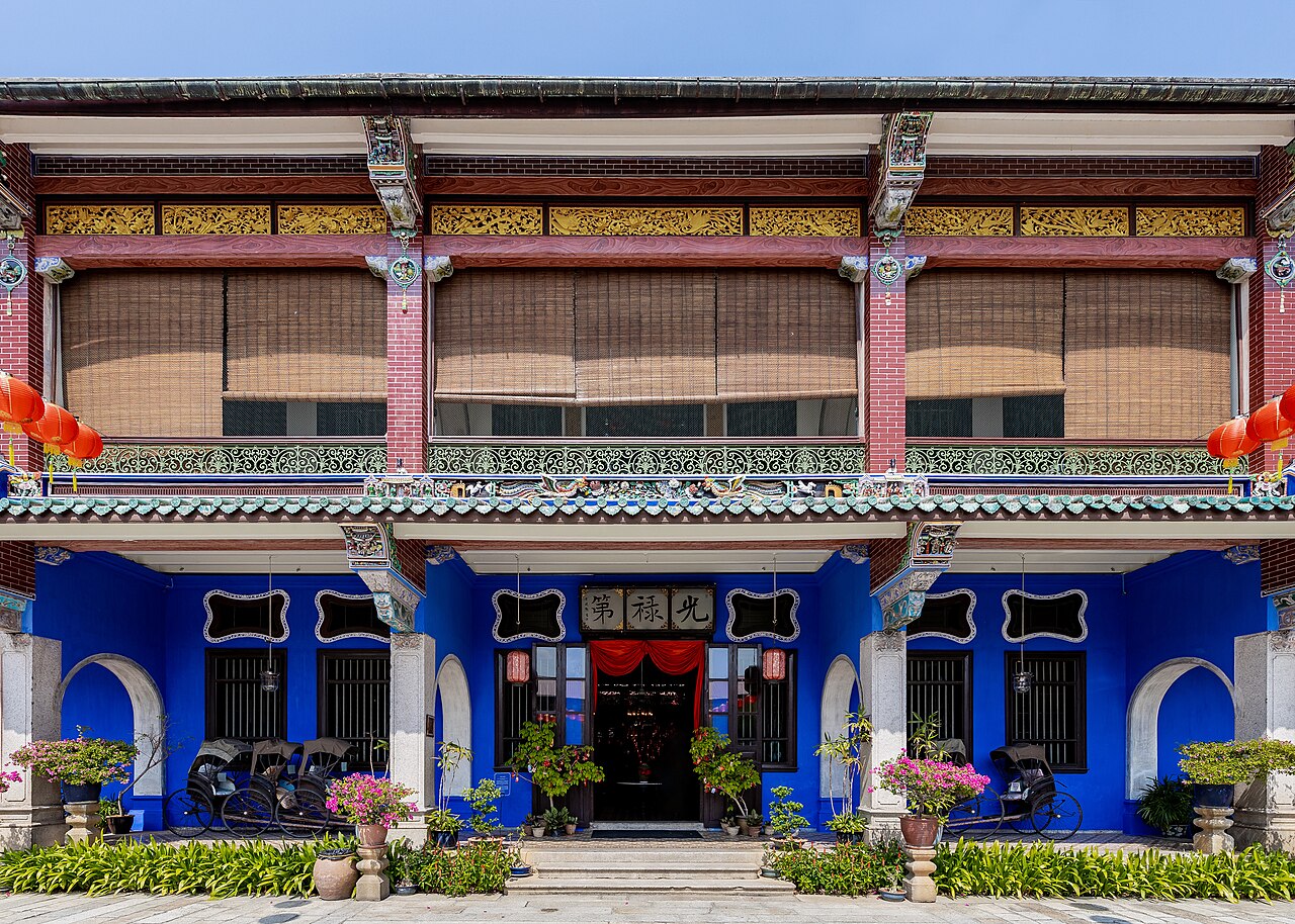 The Cheong Fatt Tze Mansion (Blue Mansion), George Town, Penang, Malaysia — an 1880s Chinese Straits Eclectic mansion of brilliant indigo-blue exterior paint, with ornate cast-iron verandah columns and louvred shuttered windows, the most celebrated individual heritage building in the UNESCO-inscribed Historic Cities of the Straits of Malacca (George Town and Melaka, inscribed 2008)