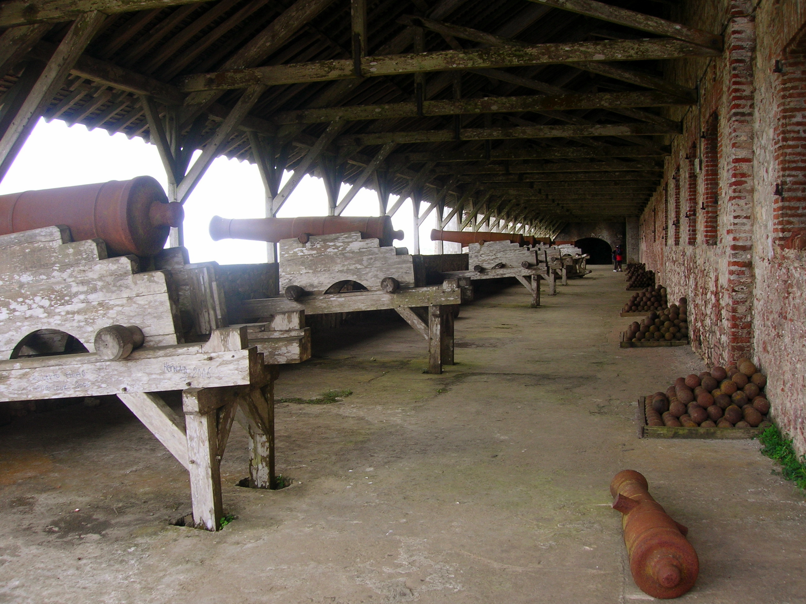 Bronze cannons lined along stone battlements inside Citadelle Laferrière