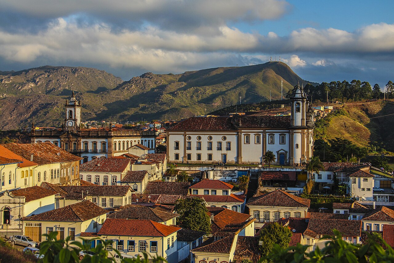 Panoramic view of Ouro Preto, the baroque colonial city of Minas Gerais, Brazil, with its hillside of red-roofed churches and whitewashed colonial buildings rising above the surrounding green mountains