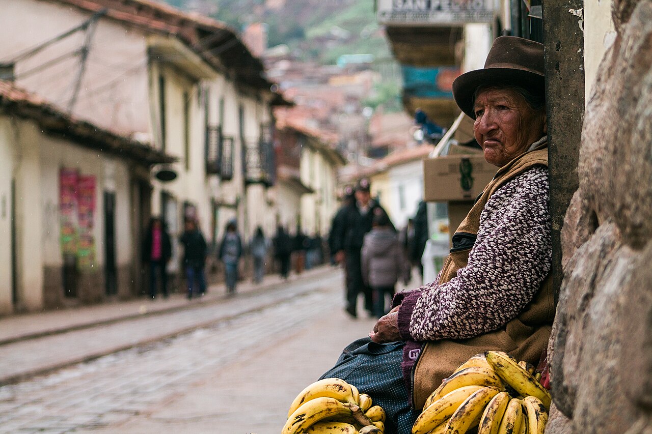 Street in historic Cusco city with Andean colonial architecture and local residents