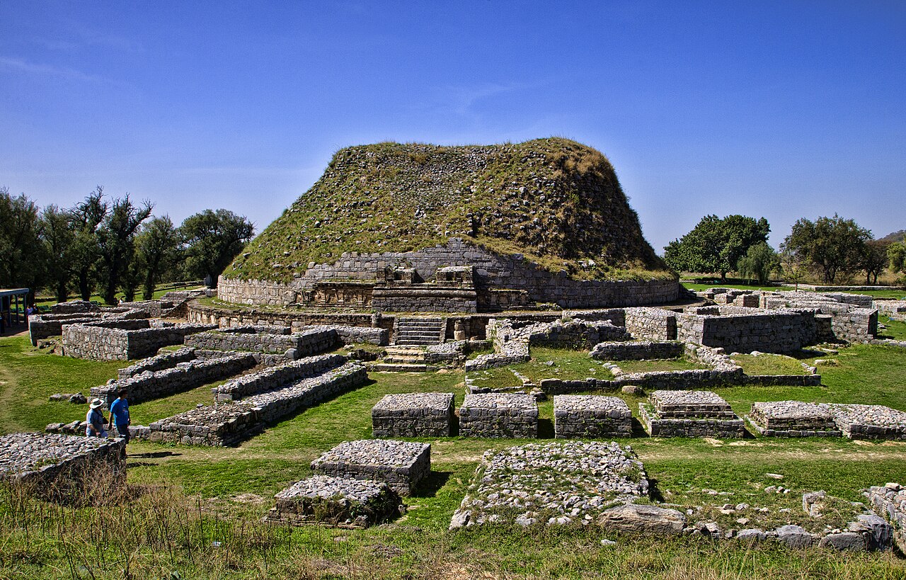 The Dharmarajika stupa at Taxila with its circular brick structure set against the Punjab hills, Pakistan