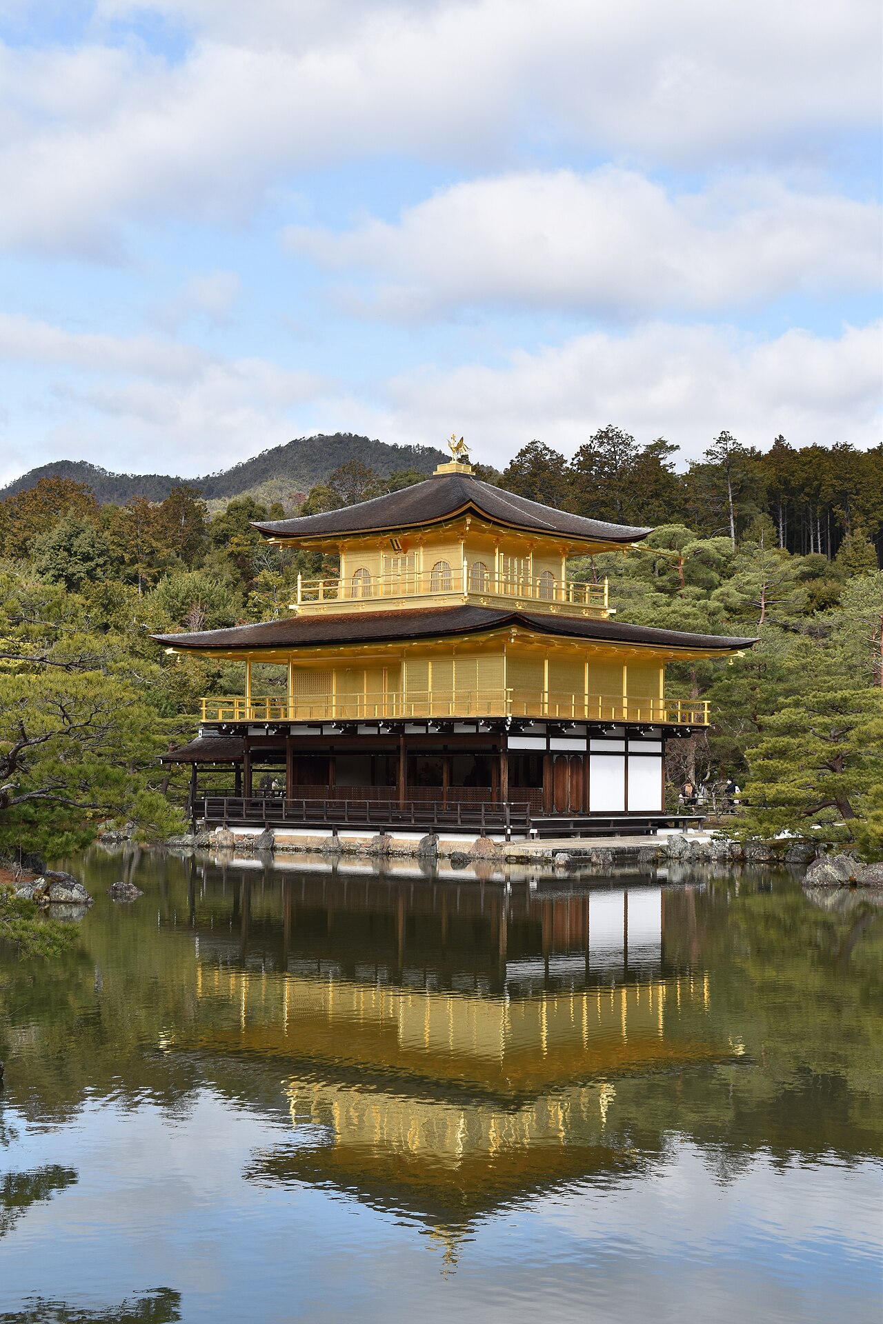 The Golden Pavilion (Kinkaku-ji / Rokuon-ji) reflected in the Mirror Pond in Kyoto, Japan — the three-story Zen Buddhist pavilion covered in gold leaf, rebuilt in 1955 after a student monk burned it down in 1950