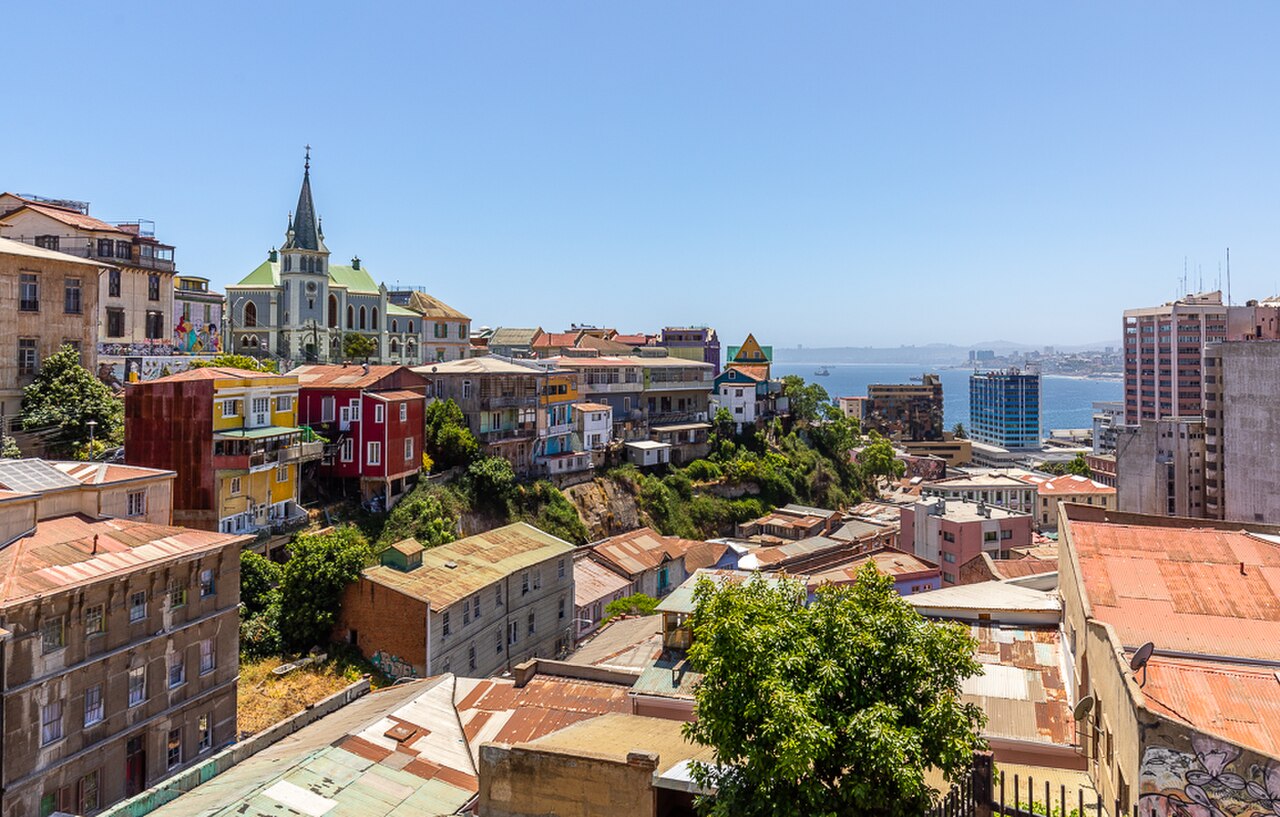 The Historic Quarter of Valparaíso, Chile — the densely painted hillside neighbourhoods (cerros) of the UNESCO-inscribed port city, with their funiculars (ascensores), Victorian mansions, and colourful corrugated-iron facades cascading down to the Bay of Valparaíso and the Pacific Ocean