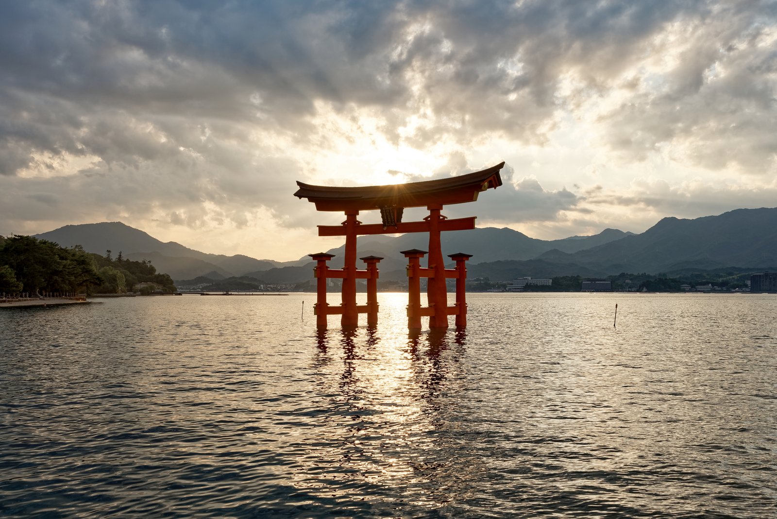 Itsukushima Shrine vermilion torii gate at sunset reflected in the Seto Inland Sea