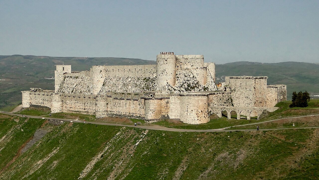 Aerial view of Crac des Chevaliers Crusader castle on a hilltop in Syria, with concentric walls and towers intact