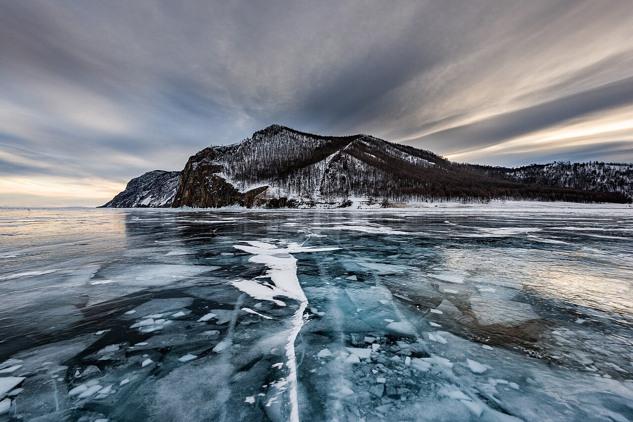Turquoise cracked ice sheets on frozen Lake Baikal surface in winter sunlight