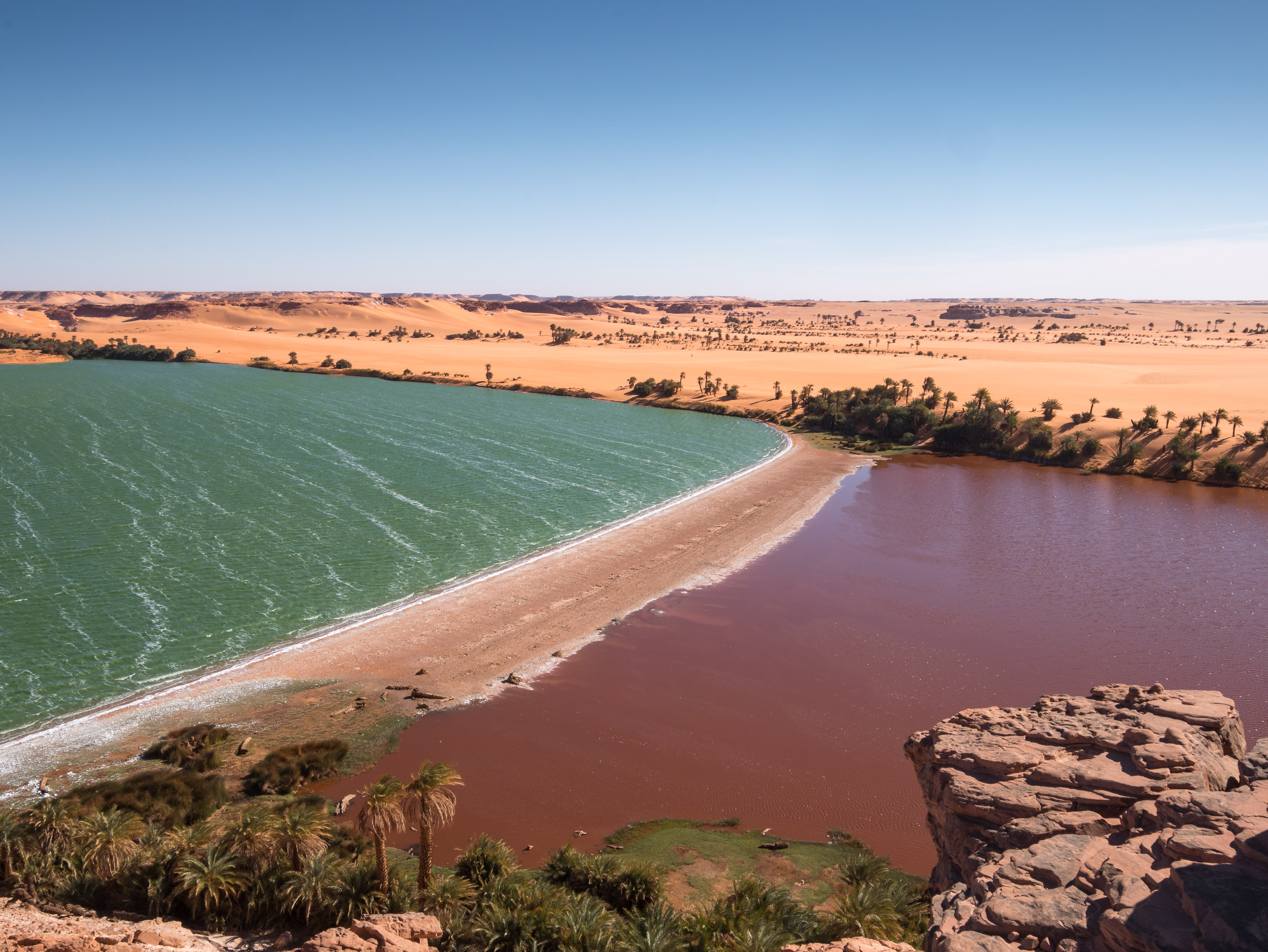 Lake Yoa at Ounianga Kebir reflecting blue sky amid Sahara desert dunes