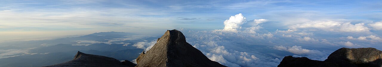 Panoramic view of Mount Kinabalu granite summit and surrounding forested ridges