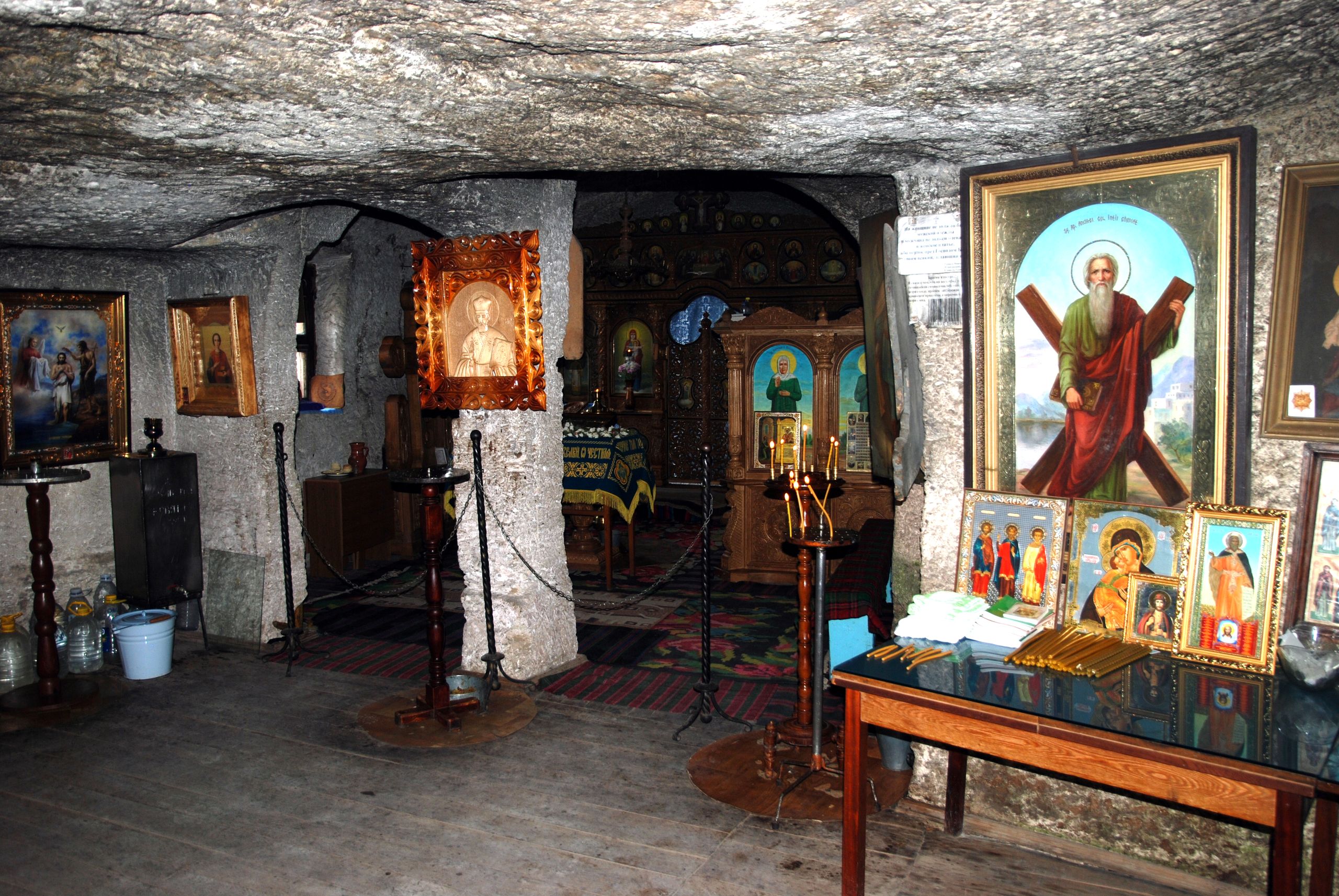 Interior of the cave monastery church at Orheiul Vechi with frescoes and carved limestone walls