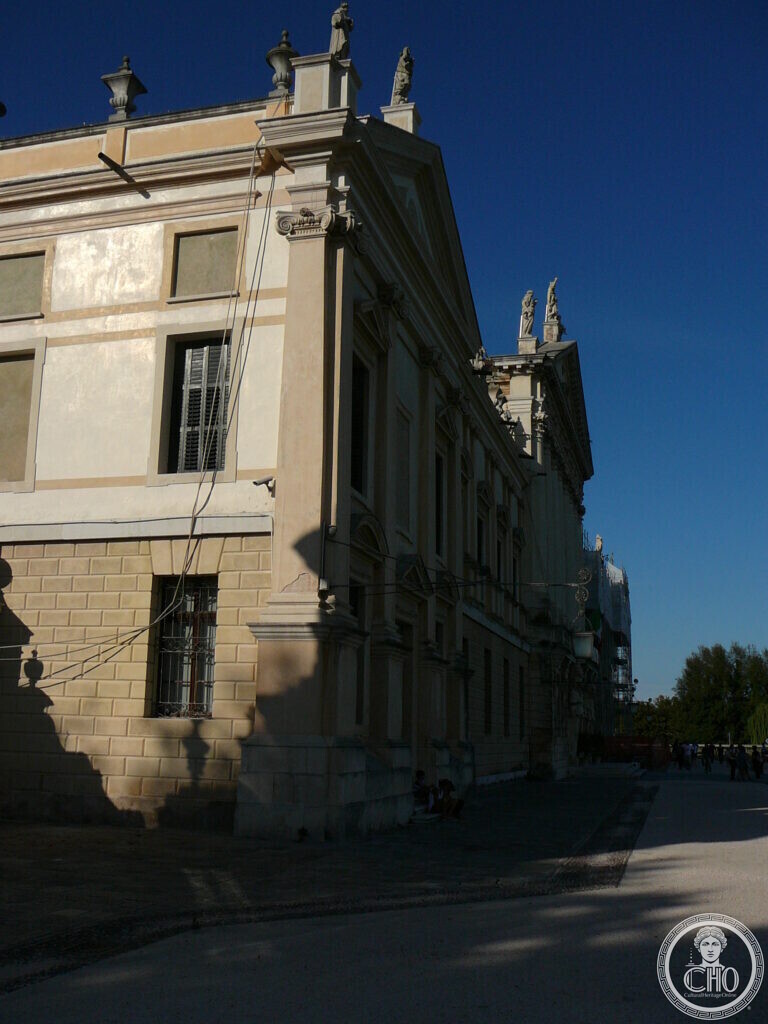 A corner of Villa Pisani at Stra in afternoon light against a deep blue sky, statues on the roofline