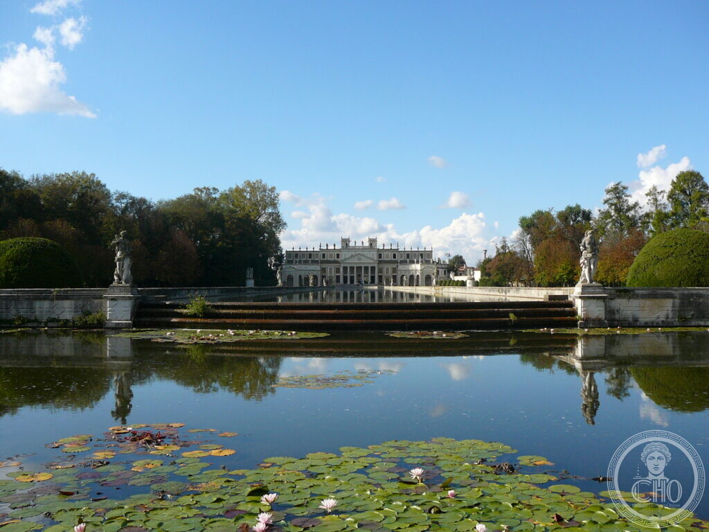 The long pool in the park of Villa Pisani at Stra, water lilies in the foreground, statues at the corners and the villa at the far end