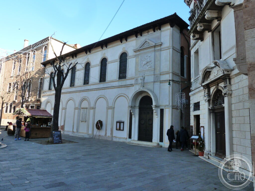 The long white flank of St George's Anglican Church along the campo in Venice, blind arcading at ground level and round-headed windows above, bare trees in front