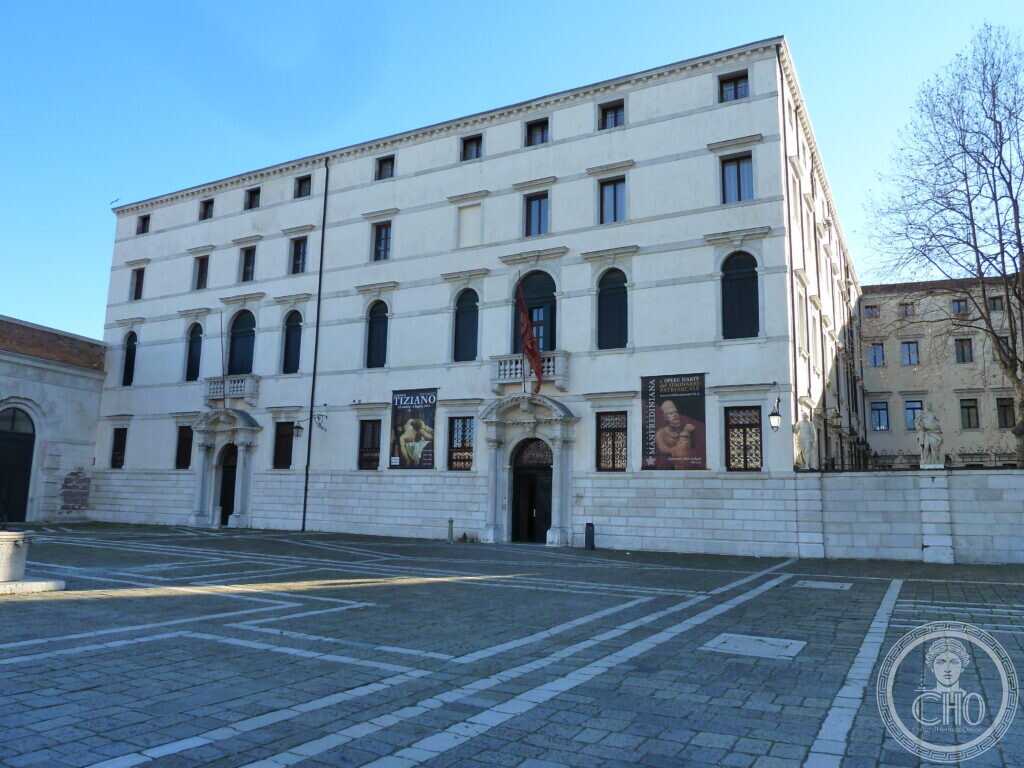 The long white front of the Palazzo del Seminario Patriarcale in Venice across its paved courtyard, four storeys of plain windows above a stone base