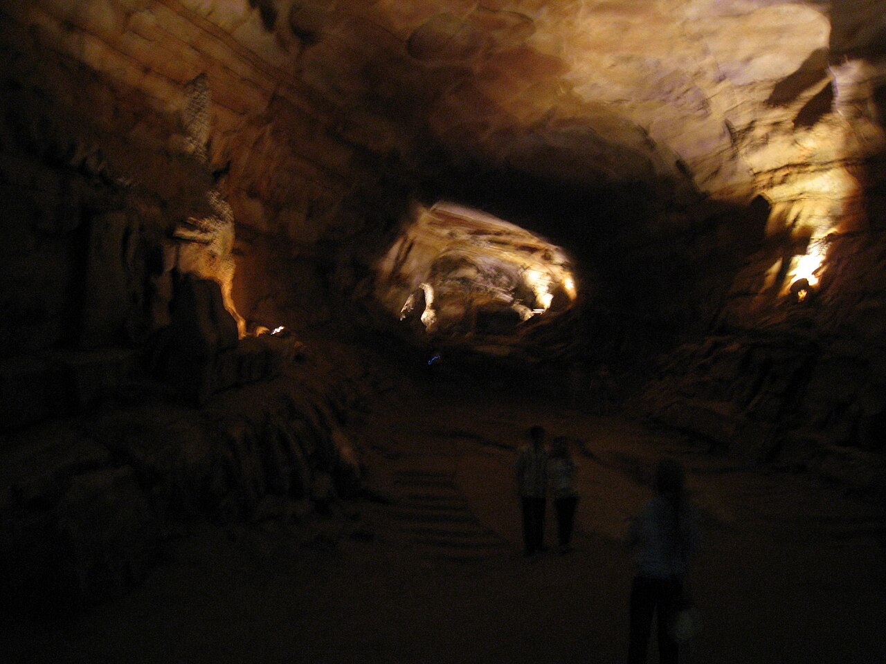 The illuminated interior of Phong Nha cave with stalactites reflected in the underground river, Vietnam