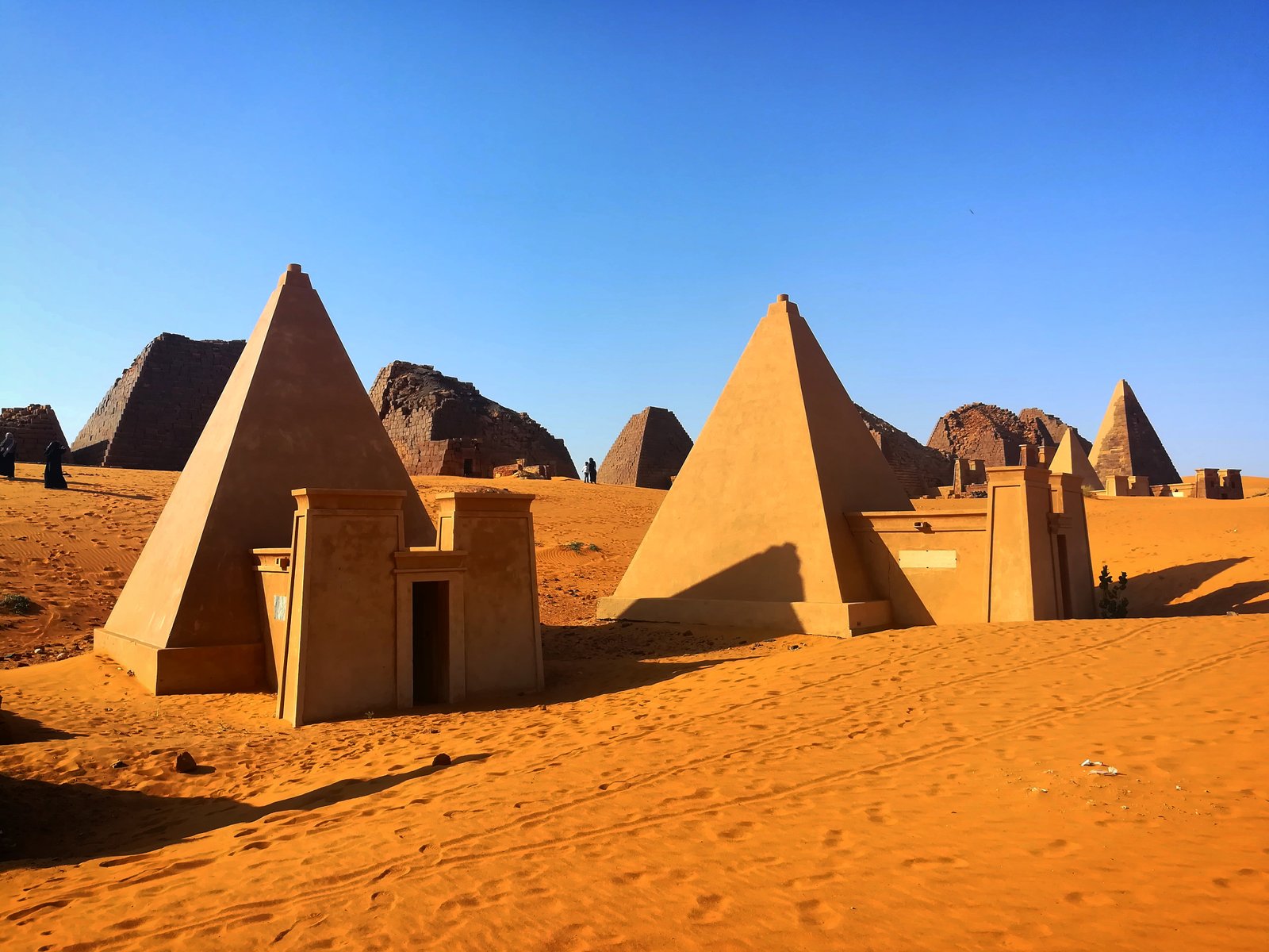 Steep-sided stone pyramids of Meroe rising from Sudanese desert sand